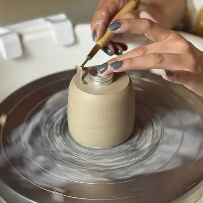 Becher aus Ton wird auf einer Drehscheibe abgedreht beim Töpfern an der Drehscheibe Workshop bei Kreativzauber in Waldshut-Tiengen