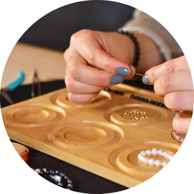 Gründerin Manja von kreativzauber by Emotion Candle fädelt im Heilsteinarmband Workshop per Hand ein Perlenarmband mit Bedeutung.